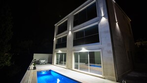 A modern two-story house with a swimming pool in the foreground. - Luxurious apartment in Postira (Postira)