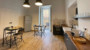 Una cocina compacta con comedor, refrigerador y estufa.