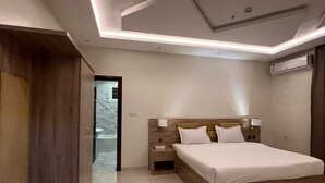 A modern bedroom with a large bed, wooden headboard, and built-in nightstands. - Sweet Star Serviced Apartments (Tabuk)
