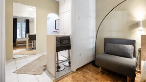 A modern room with a sofa, a mirror, and a small kitchenette. - Starry Nights - Elegent Studio in Athens (Greece - Athens)