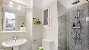 A bathroom with a white sink, toilet, and shower. There is a mirror above the sink and a window above the toilet. - Starry Nights - Elegent Studio in Athens (Greece - Athens)