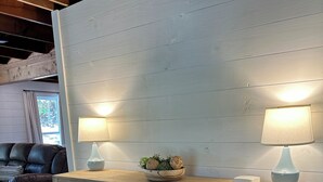 Un aparador de madera con un diseño de mosaico único, dos lámparas fijadas a la pared y un cuenco decorativo encima.