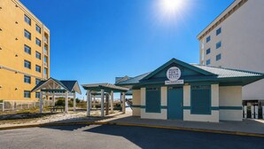 A public beach access building with a sign, a covered picnic area, and a parking lot. - Tiny Home on the Boardwalk | Walk to the Beach (Fort Walton Beach)