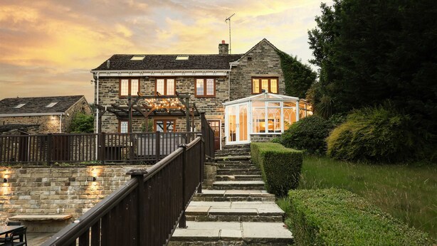 A stone house with a glass conservatory, stone steps, and a wooden fence. - Habberjam Farm: Swimming Pool, Sauna, Hot Tub, Fire Pit (Marsh Lane)