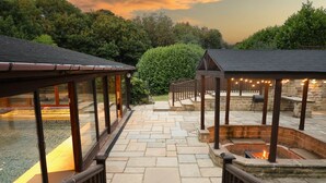 A patio area with a fire pit, stone flooring, and wooden pergolas. - Habberjam Farm: Swimming Pool, Sauna, Hot Tub, Fire Pit (Marsh Lane)