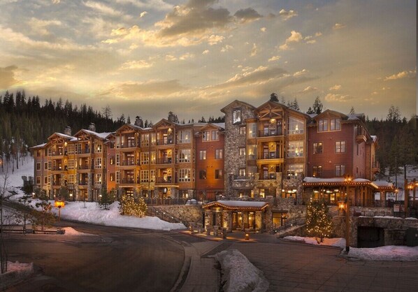 Stunning mountain lodge with a traditional design, set amidst a serene winter wonderland.