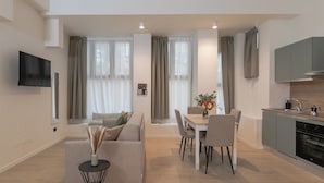 A modern apartment with a living room, dining area, and kitchen.