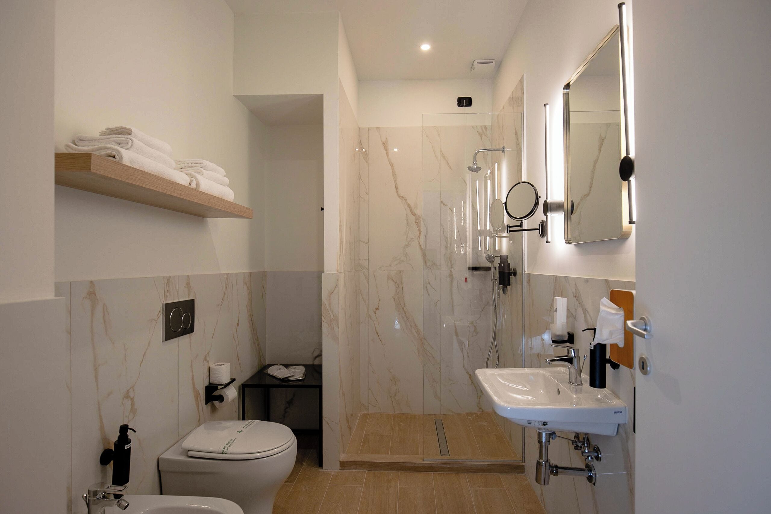 Ein modernes Badezimmer mit Toilette, Waschbecken und Dusche.