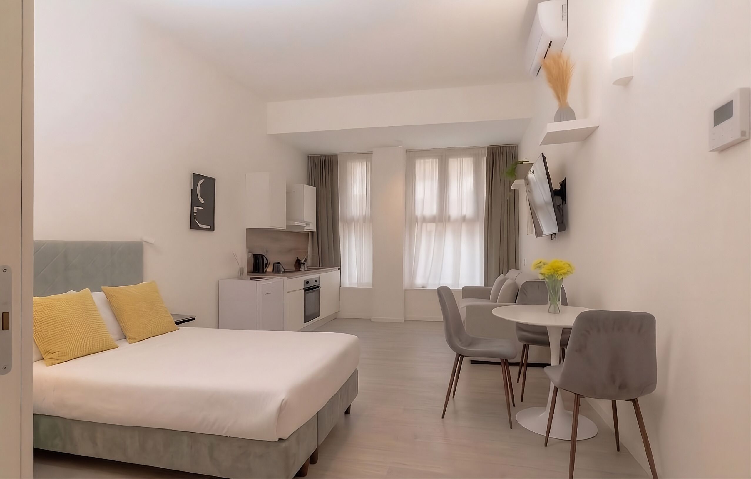 Une chambre d’hôtel moderne équipée d’un lit, d’un coin repas et d’une kitchenette.