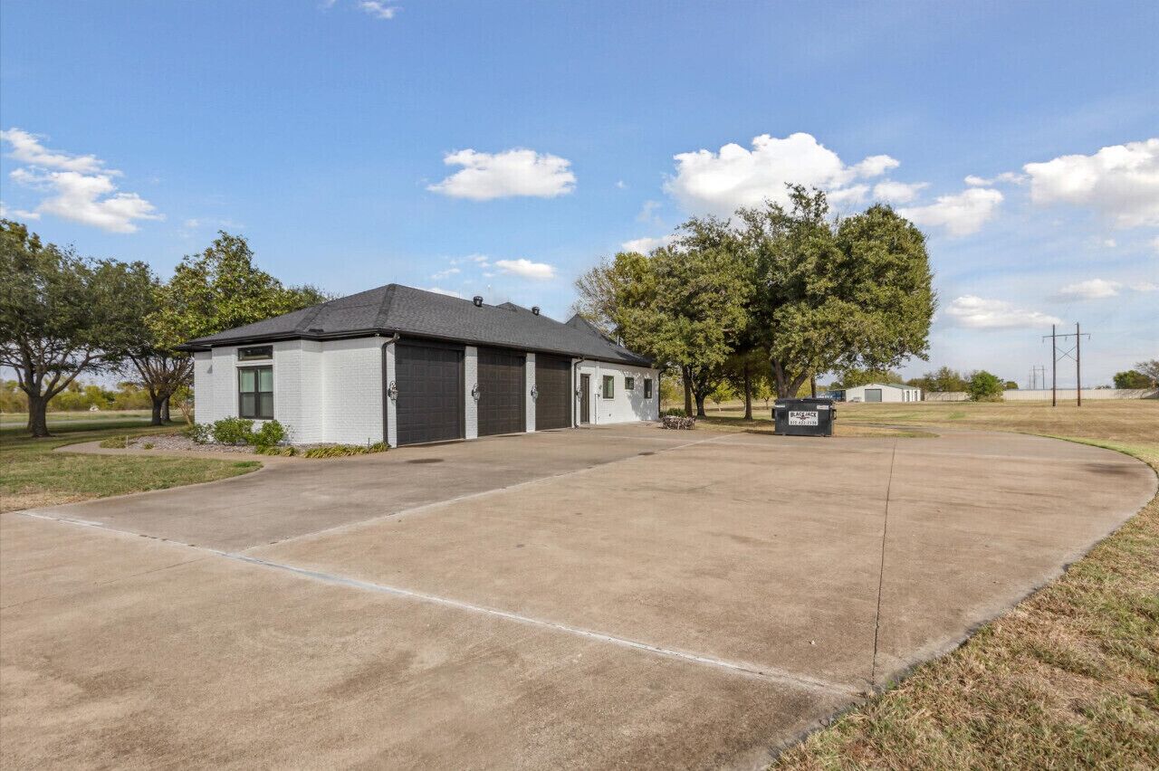 A single-story building with a garage, a covered parking area, and a clear sky.