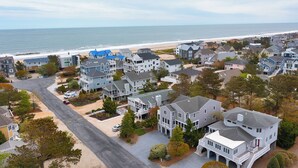 A coastal residential area with houses, a beach, and a clear view of the ocean.