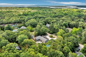 A large, secluded property with multiple houses surrounded by dense forest, a swimming pool, and a view of the ocean. - The Salt Pond House - Your Pool Escape By The National Seashore RPAM105 (Eastham)