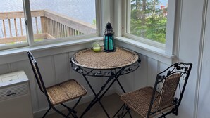 Una habitación con vistas a un lago, una mesa redonda con sillas y un calentador.