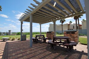 Relax under the shade of a pergola, surrounded by lush greenery and brick structures.