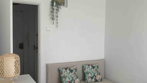 Une chambre à coucher avec un lit, une plante suspendue, une lampe et un luminaire au plafond.