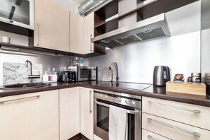 A modern kitchen with a built-in microwave, toaster, and oven. - Top floor near ferry terminal. Free parking. (Tallinn)