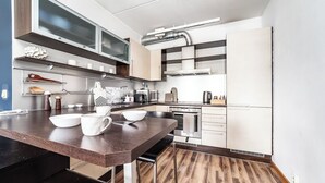 Une cuisine moderne dotée d’un plan de travail en bois, d’appareils électroménagers intégrés et d’un pare-feu.