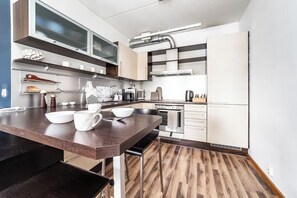 Een moderne keuken met een houten aanrechtblad, inbouwapparatuur en een spatwand.