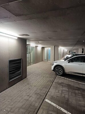 A parking garage with a white car parked in a designated space.