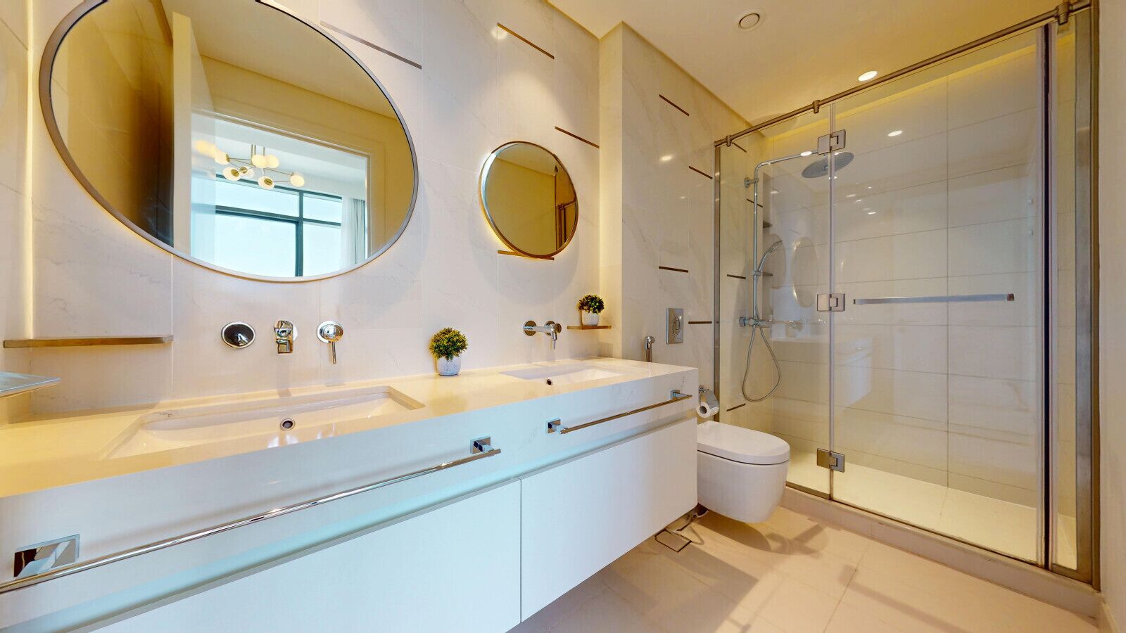 Ein modernes Badezimmer mit einem großen Spiegel, zwei Waschbecken, einer Glasdusche und einer Toilette.