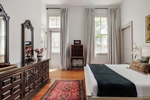 Ein Schlafzimmer mit einem Bett, einem Schminktisch, einem Spiegel und einem Schrank mit Dekorationen.