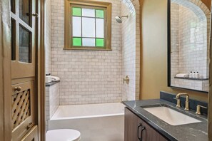 Een badkamer met een bad, een wastafel en een toilet.