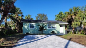 A single-story house with a paved driveway leading to a front door.