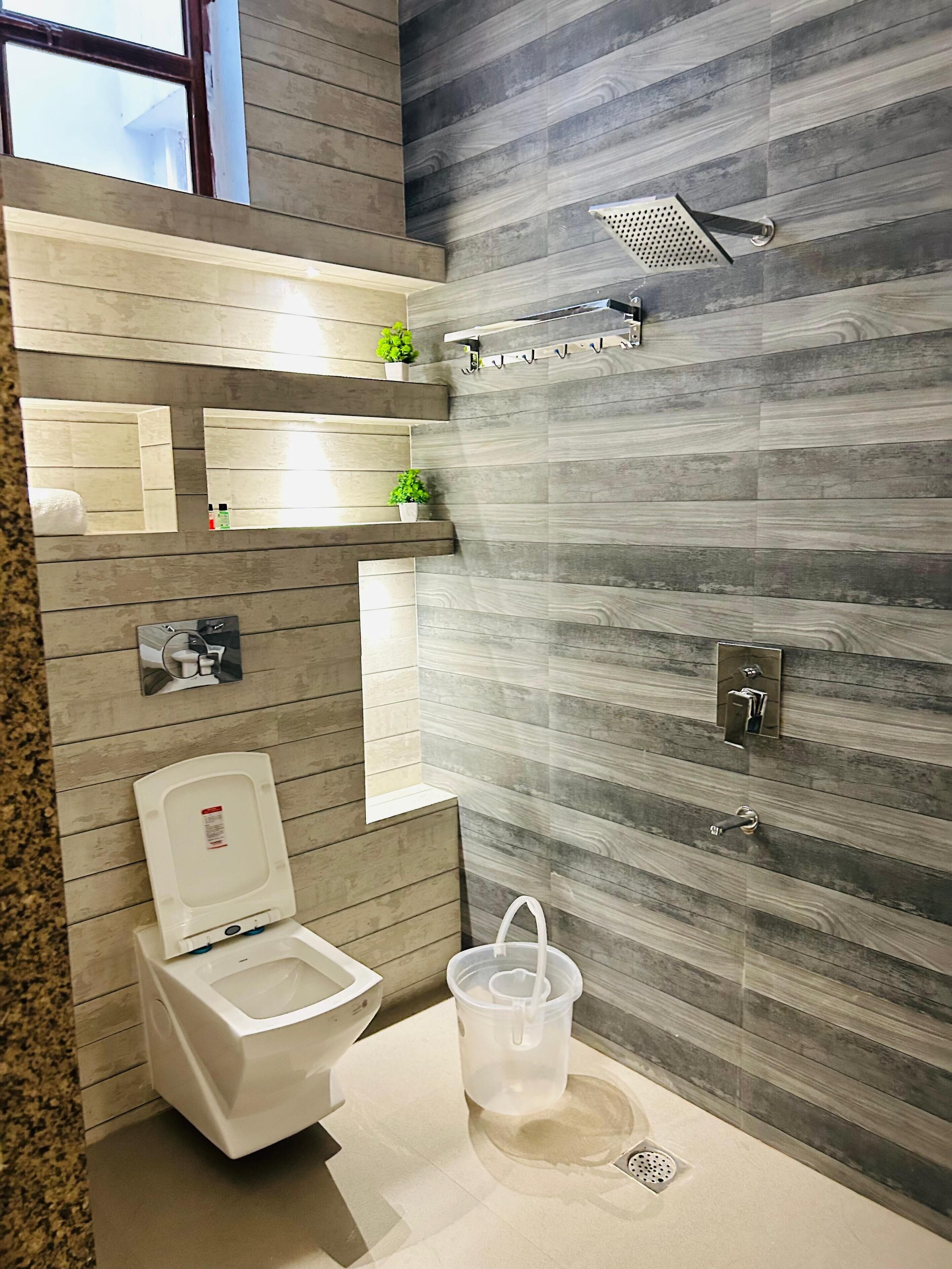 A modern bathroom with a toilet, shower, and sink.