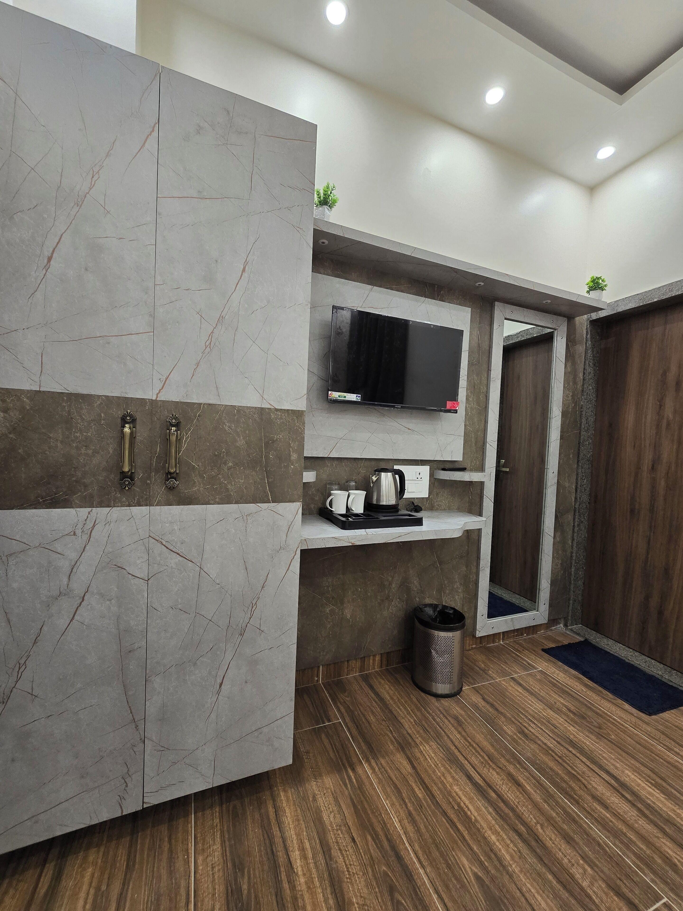 A modern kitchen with a built-in microwave, a coffee maker, and a trash bin.