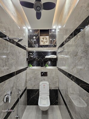 A modern bathroom with a toilet, bidet, and shower. - Hotel Kashi Mantram (Varanasi)