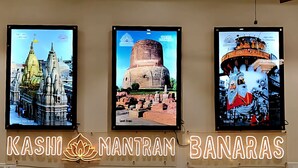 Ένα σαλόνι με έναν καναπέ, έναν ανεμιστήρα οροφής και τρεις φωτογραφίες σε κορνίζες τοποθετημένες στον τοίχο.