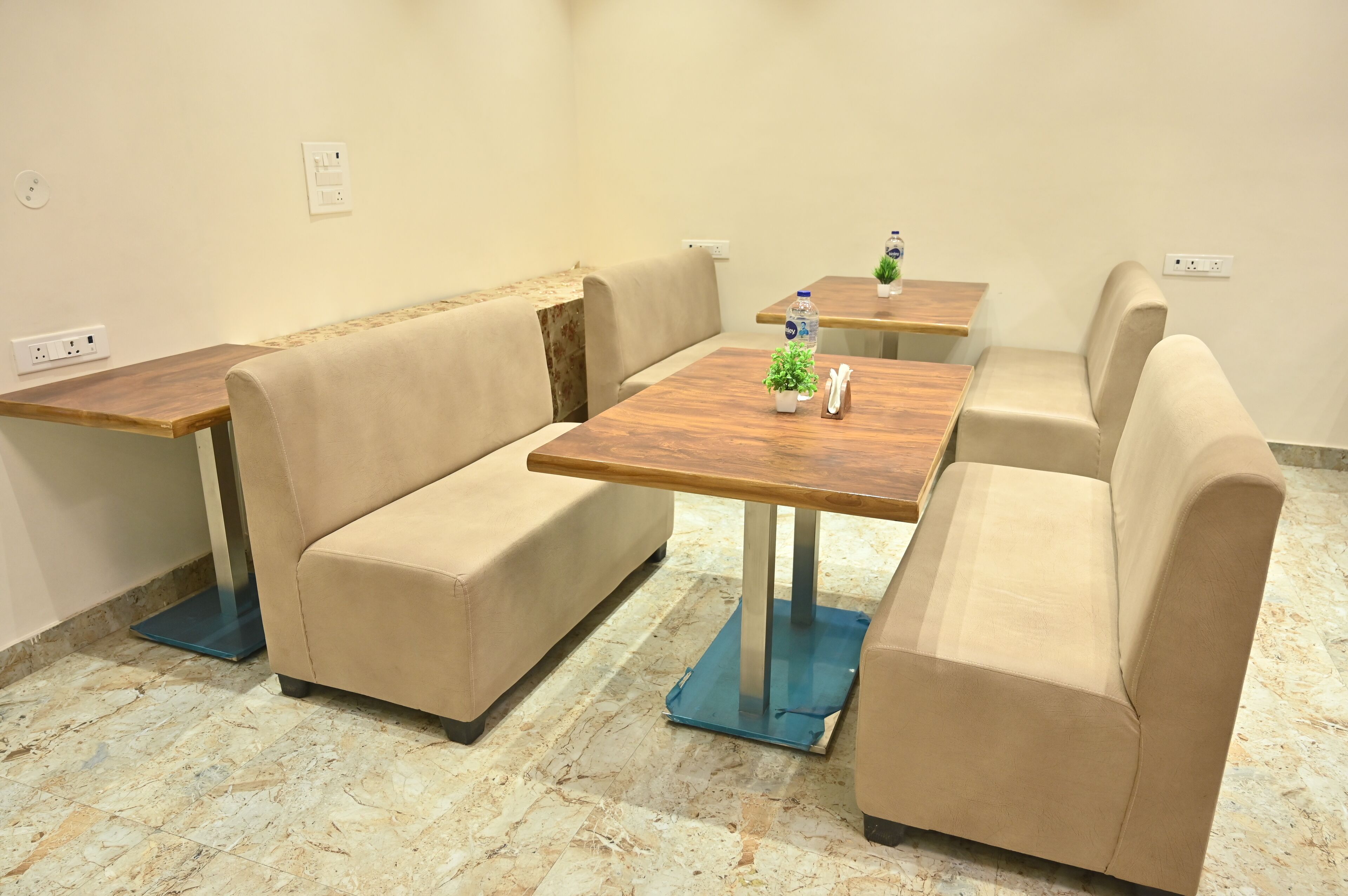 Eine Sitzecke mit beigefarbenen Sofas und einem Holztisch, ausgestattet mit einer Waage und einer kleinen Pflanze.