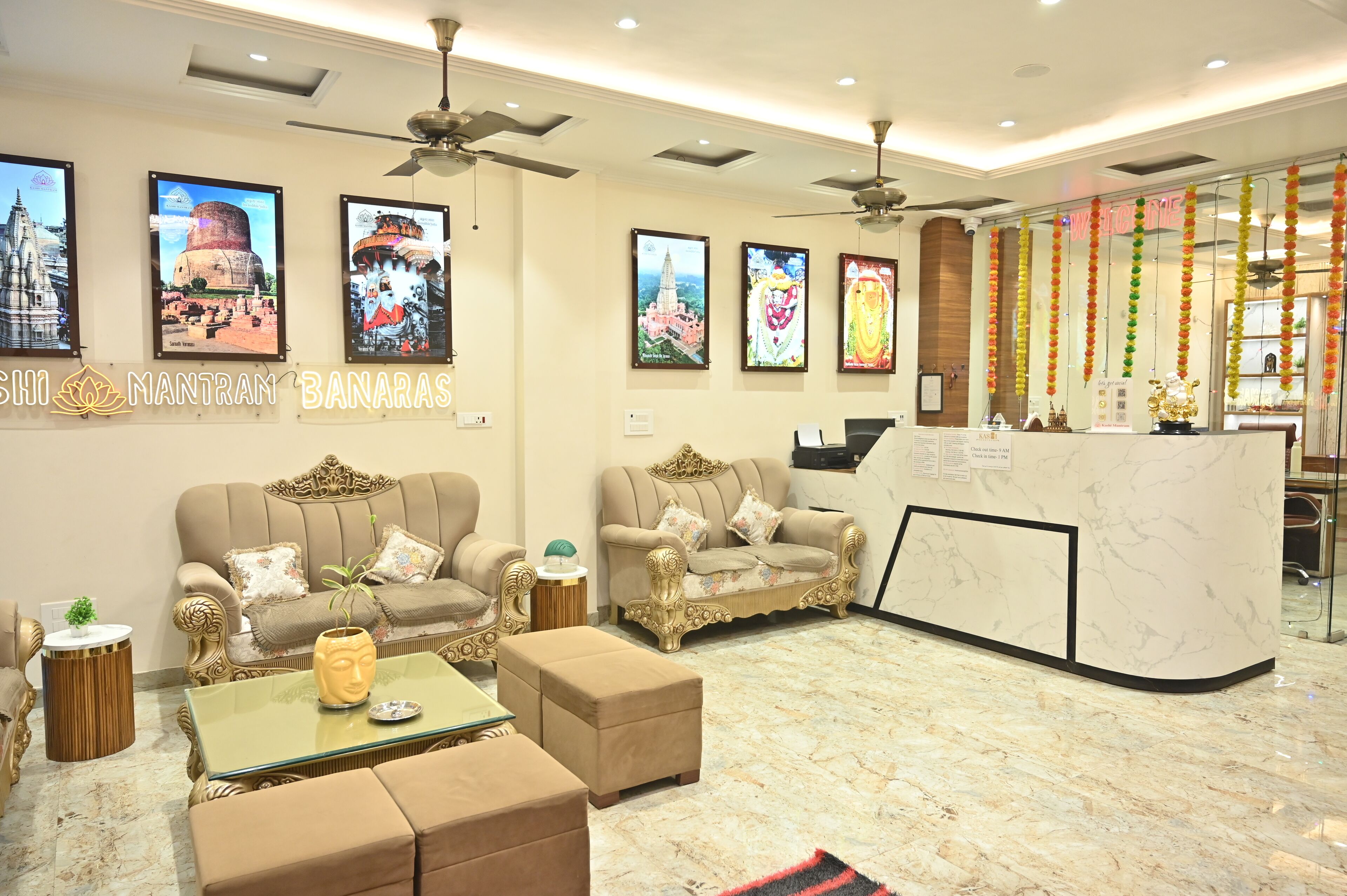 Una hall d'albergo con divani decorati, una reception e quadri appesi alle pareti.