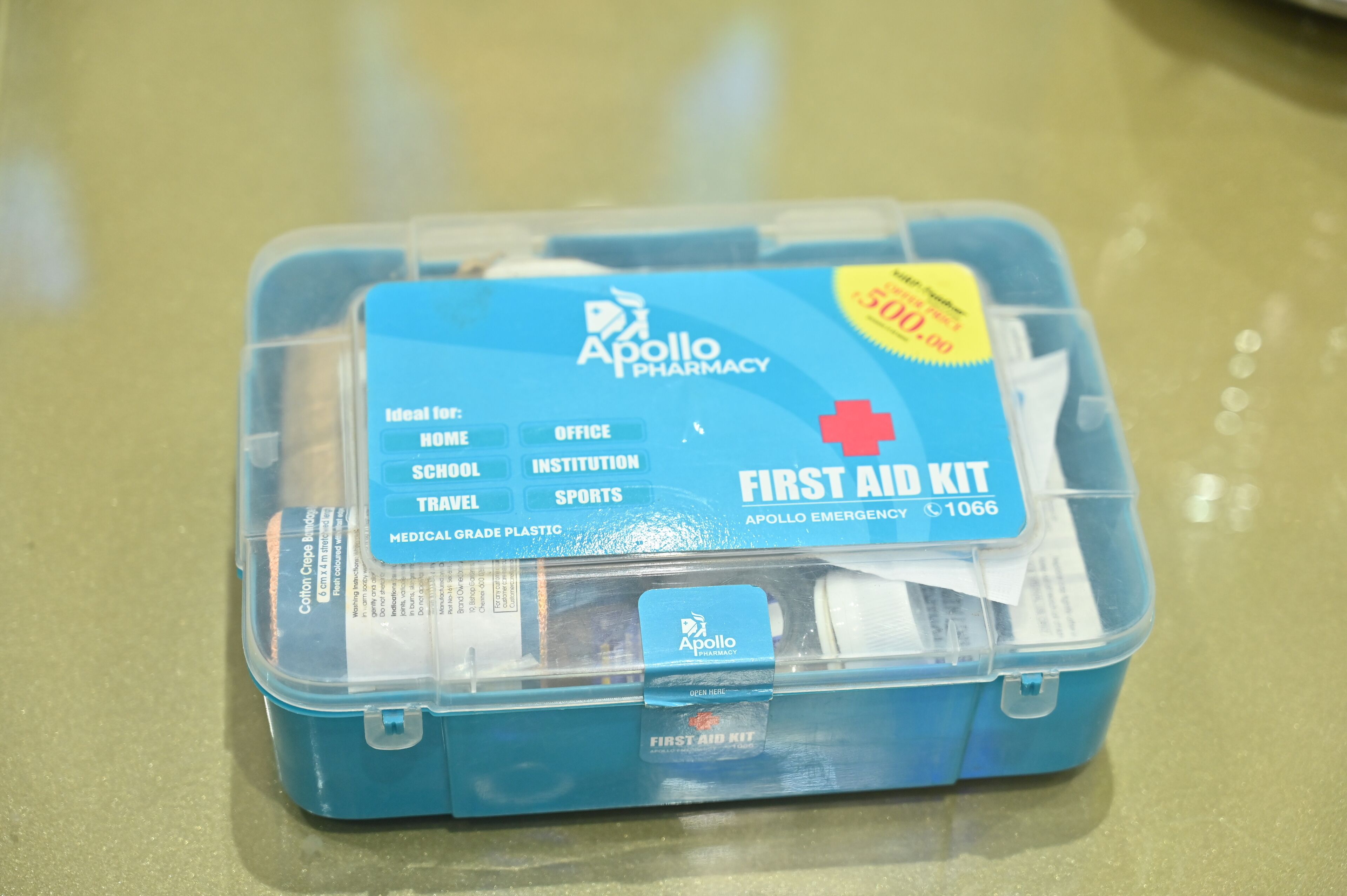A blue Apollo Pharmacy first aid kit on a countertop.
