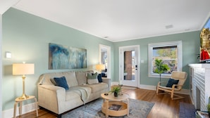 A living room with a beige sofa, a round coffee table, and a blue rug.