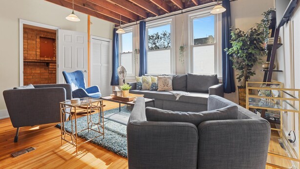 Un salon moderne avec une cheminée, un ensemble de canapés, une table basse et un fauteuil bleu.