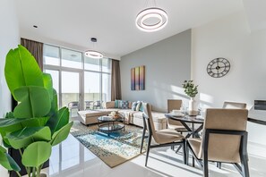 A modern living room with a sofa, coffee table, and dining area.