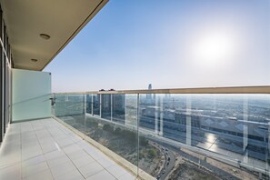 A high-rise building with a glass balcony overlooking a cityscape. - Elegant 2BR in Tower 108 Jumeirah Village Circle by Deluxe Holiday Homes (Dubai)