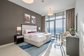 Ein modernes Hotelzimmer mit einem großen Bett, einem Schreibtisch und Blick auf die Stadt.