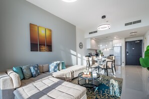 Una sala moderna con un sofá, una mesa de centro y un comedor con sillas y una mesa.