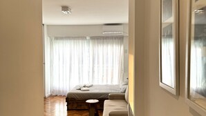 A hotel room with a bed, a small round table, and a sofa. - Bright Apartment with Terrace to Faculties (Buenos Aires)