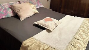 Une chambre à coucher avec un lit, des oreillers et une armoire.