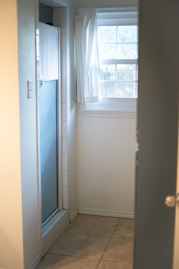 A narrow hallway with a door on the left and a window on the right. - Sun's Up, Gun's Up 2 bedroom Cottage in Lubbock TX in Tech Terrace (Lubbock)