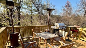 A wooden deck with a grill, a table, and chairs. - The Sun Filled Cozy Creamery (Plainville)