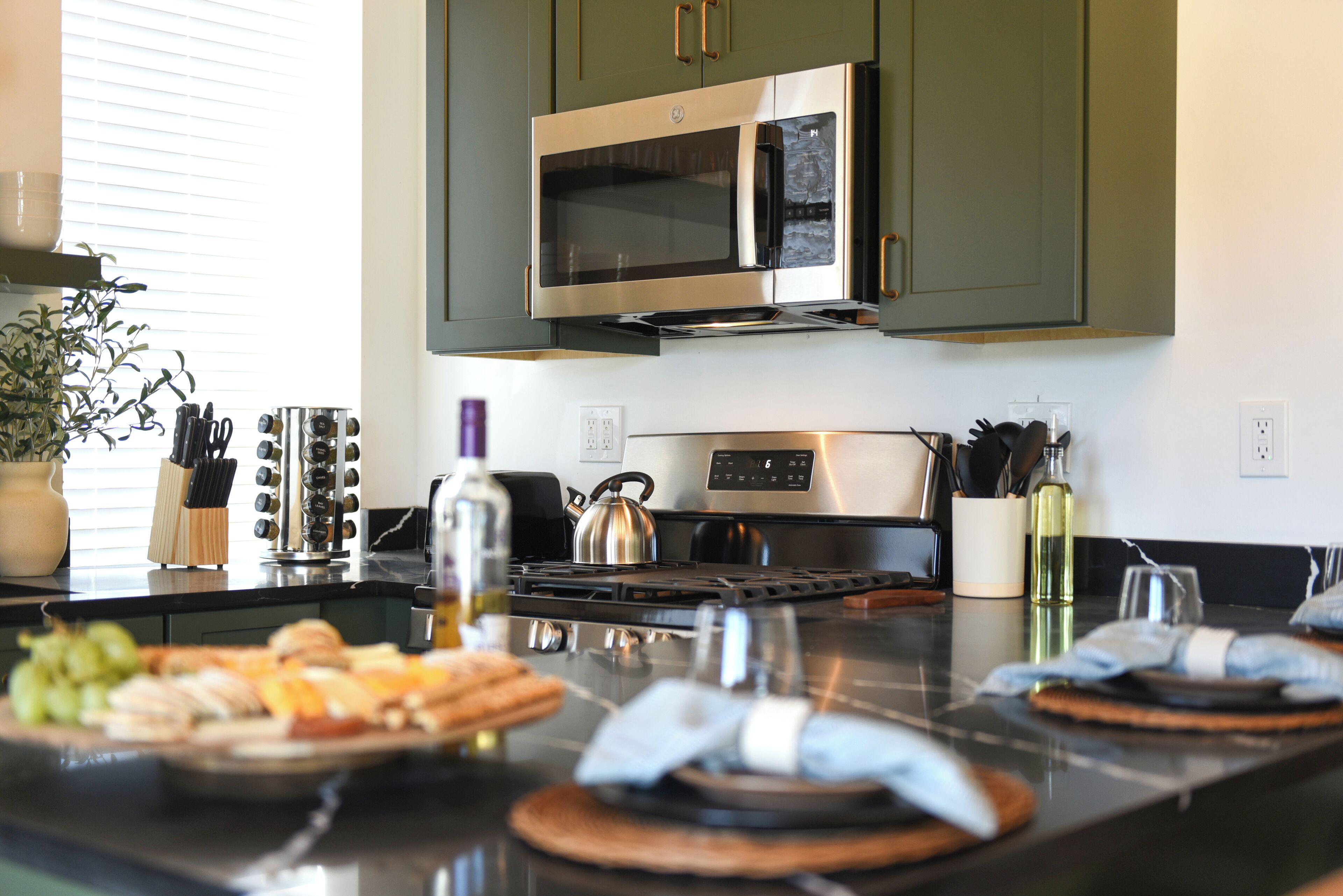 A modern kitchen with stainless steel appliances, a gas stove, and a microwave.