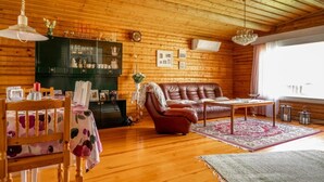 Un intérieur chaleureux en bois, avec une table à manger, des chaises, un canapé et une cheminée.