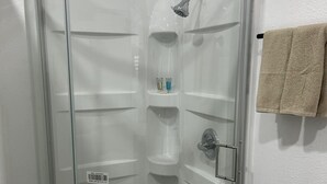 A glass-enclosed shower stall with a handheld showerhead, a soap dish, and a towel rack. - Charming barn with WiFi and AC in enchanting Intercession City (Intercession City)