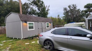 A small shed with a sloped roof and a car parked in front. - Charming barn with WiFi and AC in enchanting Intercession City (Intercession City)