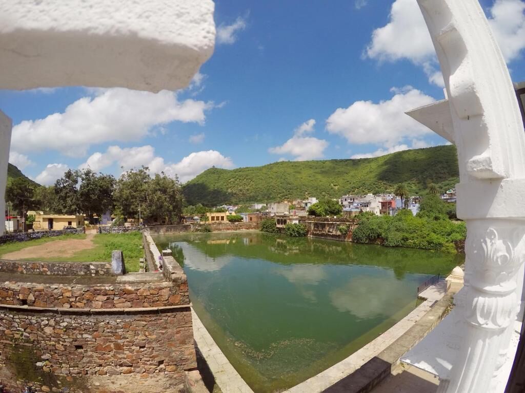Vista de un río, un muro de piedra y una estructura blanca al frente.