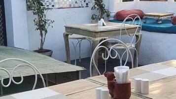 Enjoy a romantic meal for two in this charming outdoor dining area, complete with a beautifully set table and a serene view.